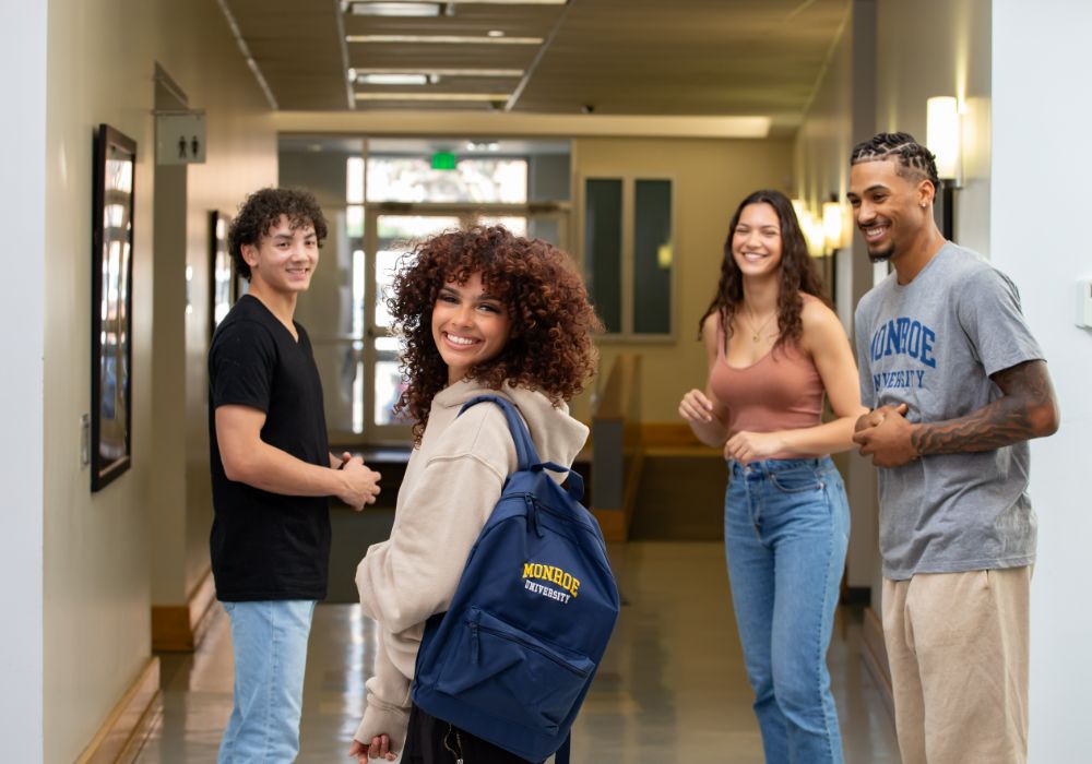 Four students standing in a hallway.