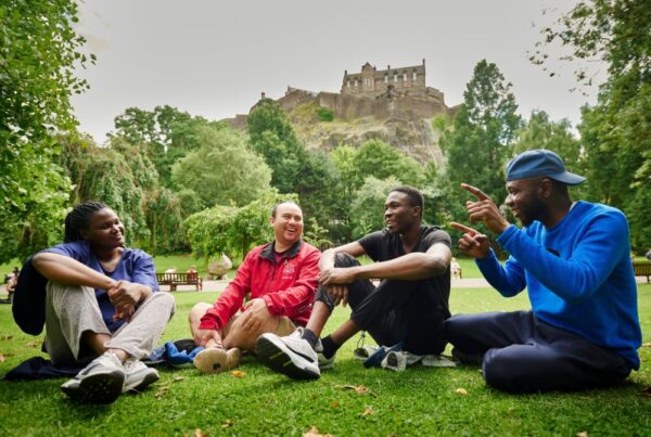 Four young people relax on the grass.